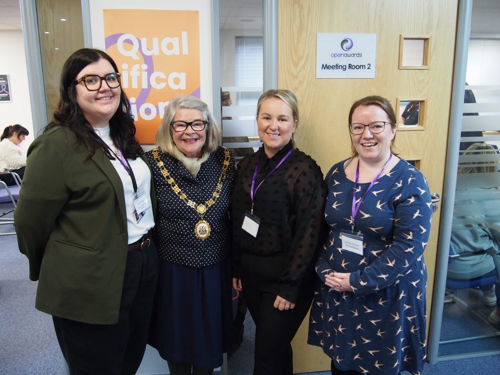 Open Awards staff and a guest wearing a mayoral chain stand together outside Meeting Room 2 at an Open Awards event.